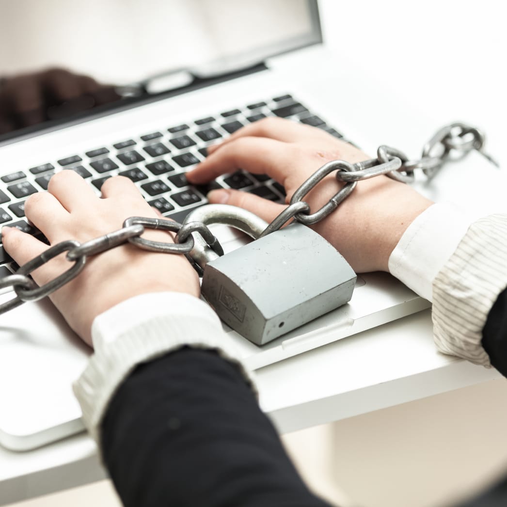 Hands chained to a laptop